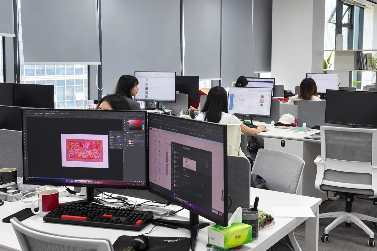 Office staff working at computer desks in a shared workspace