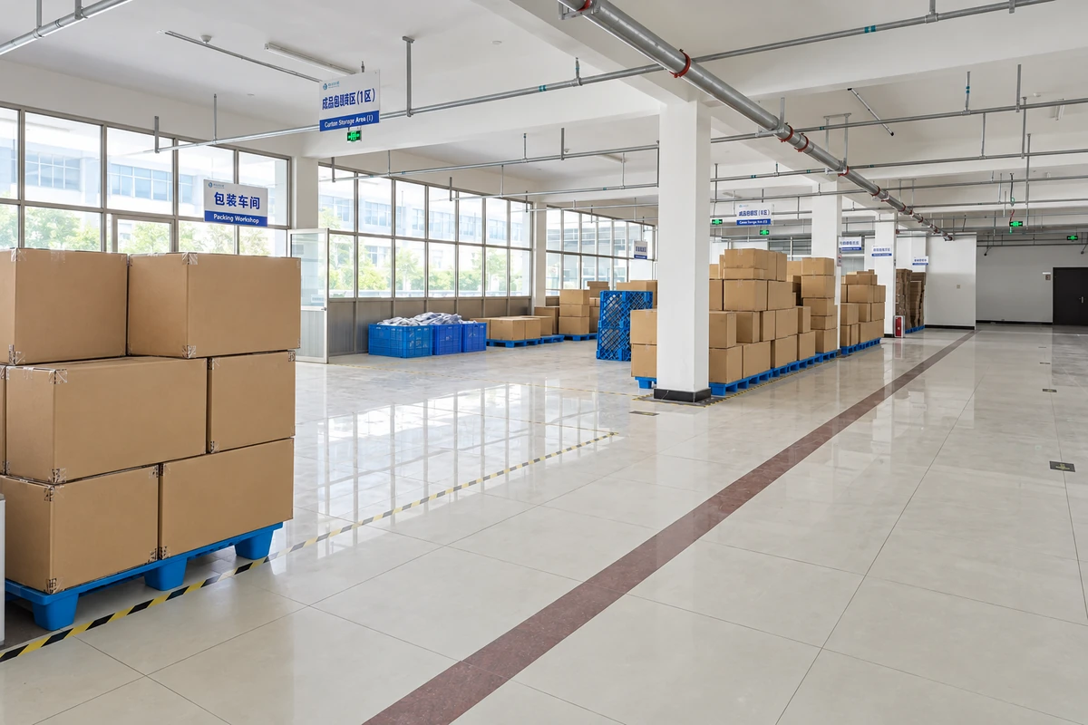 Sealed cartons grouped on blue pallets inside a packing workshop