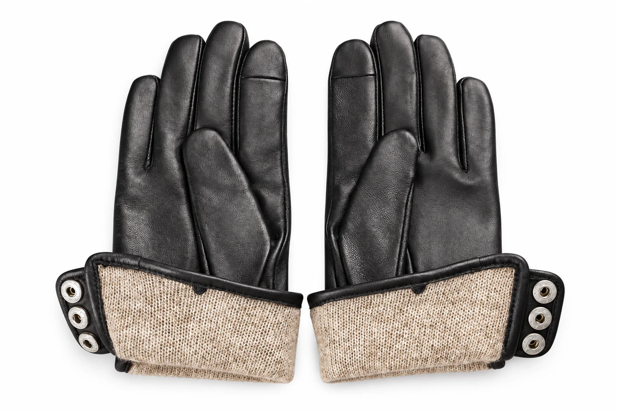 Black leather gloves with opened cuffs showing tan lining and snap fasteners