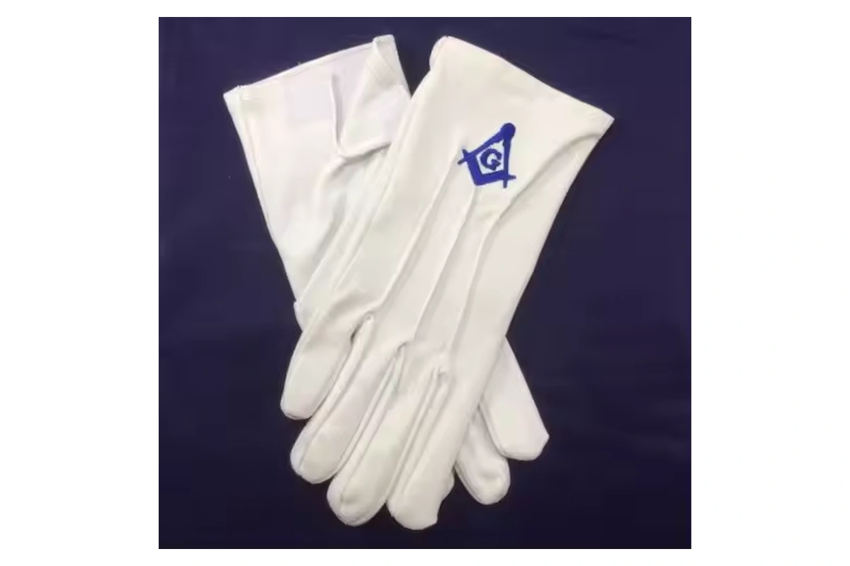 White gloves with a blue embroidered square-and-compass emblem on one cuff
