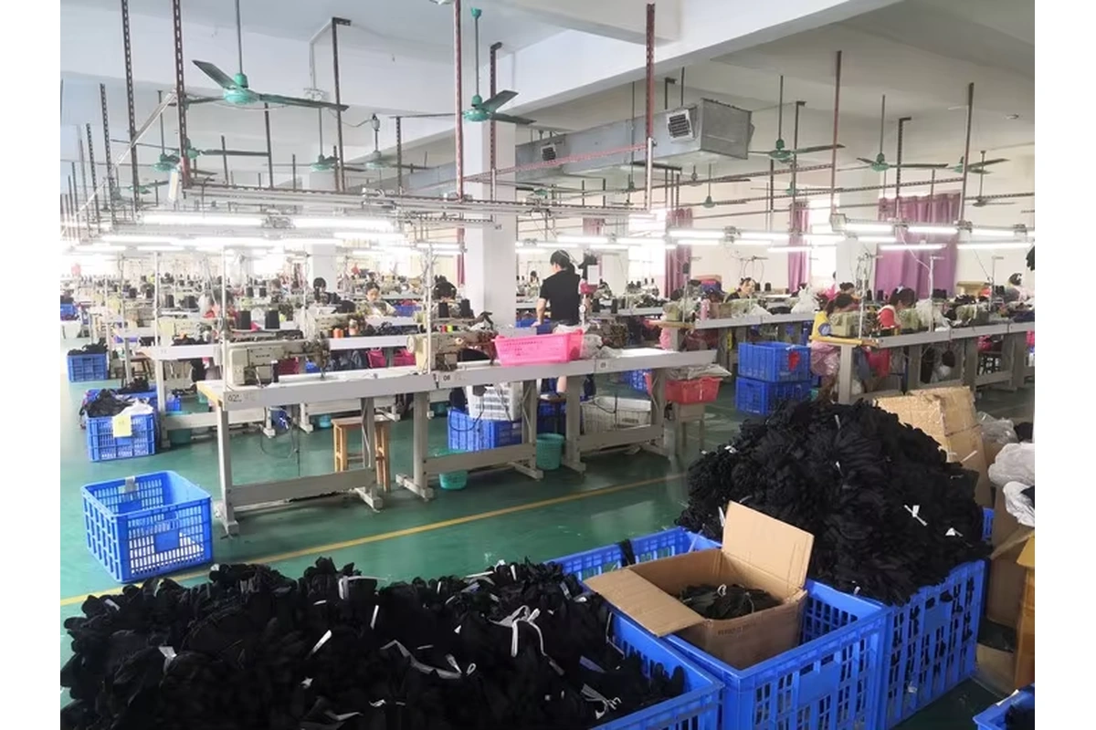 Glove workstations with batches of black gloves in blue bins