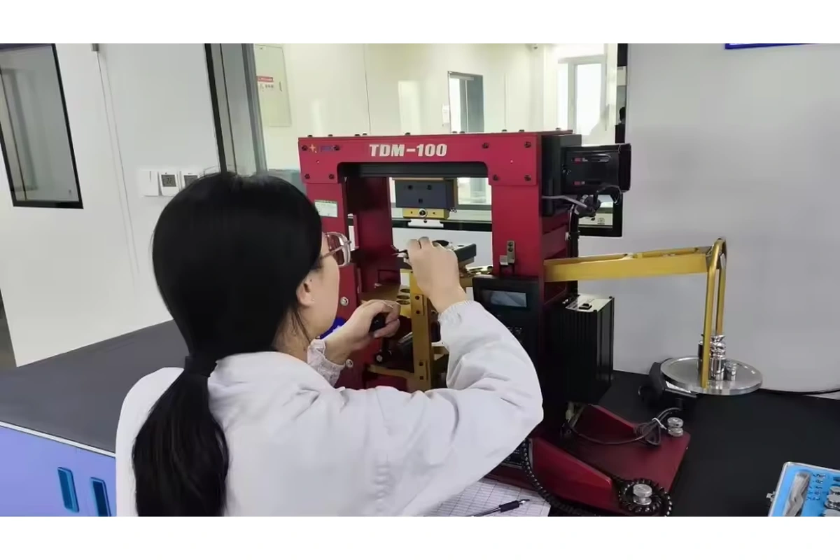 Laboratory operator positioning a specimen in a red test machine