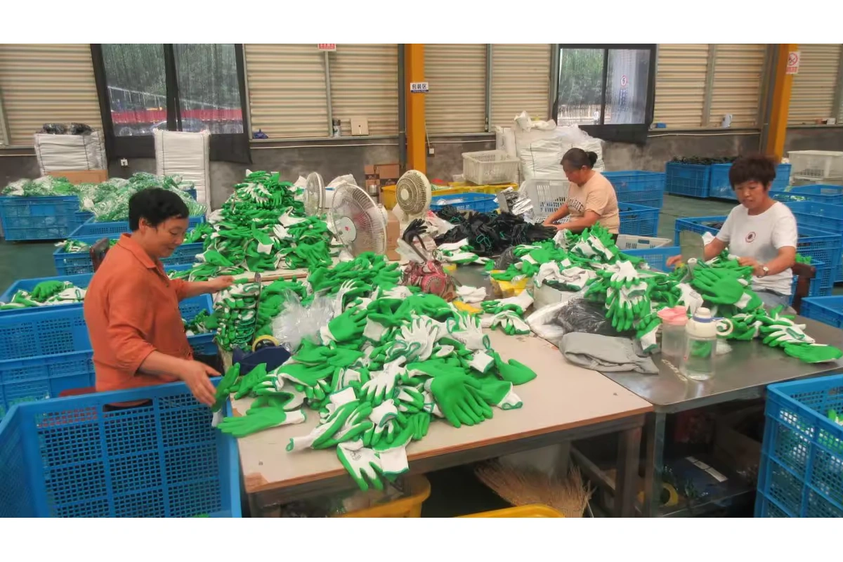 Workers sorting and pairing green-and-white gloves at a packing table