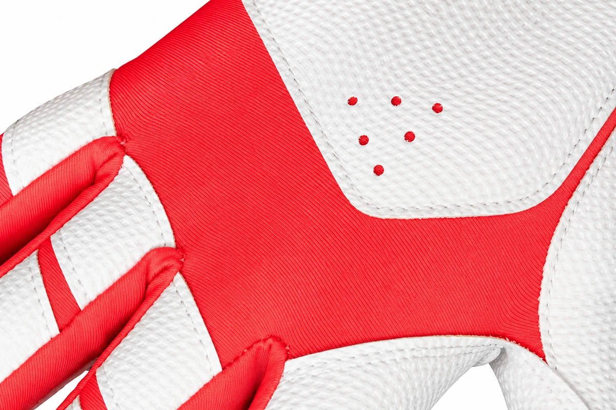 Stitched joins between red and white batting glove panels