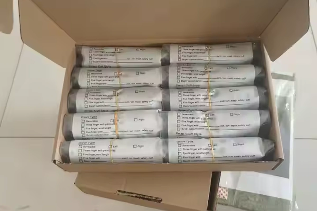 Individually wrapped gloves with paper labels arranged in an open carton