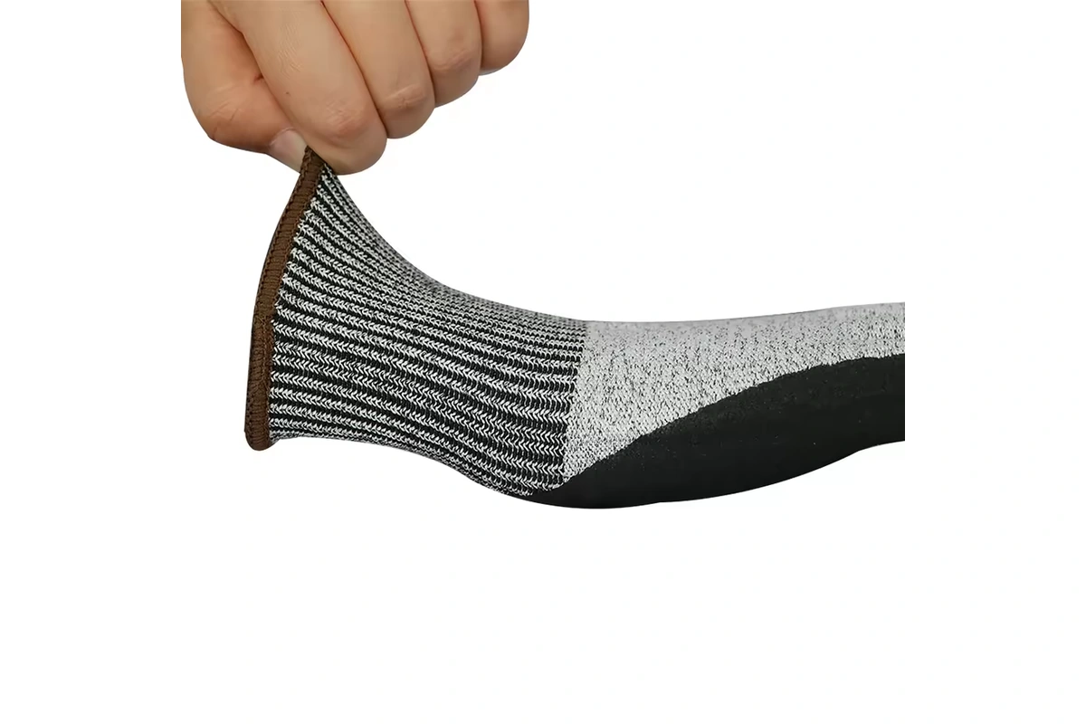 Hand stretching the ribbed cuff of a gray and black glove