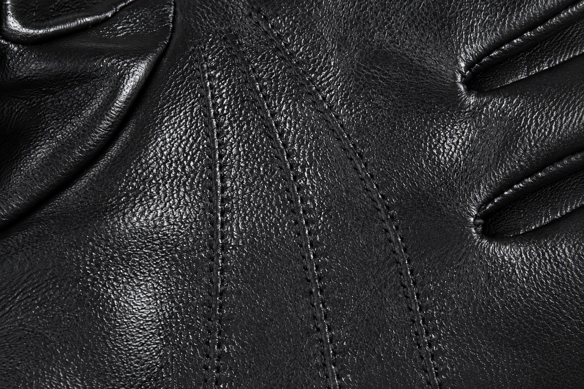 Black leather grain and stitched surface detail