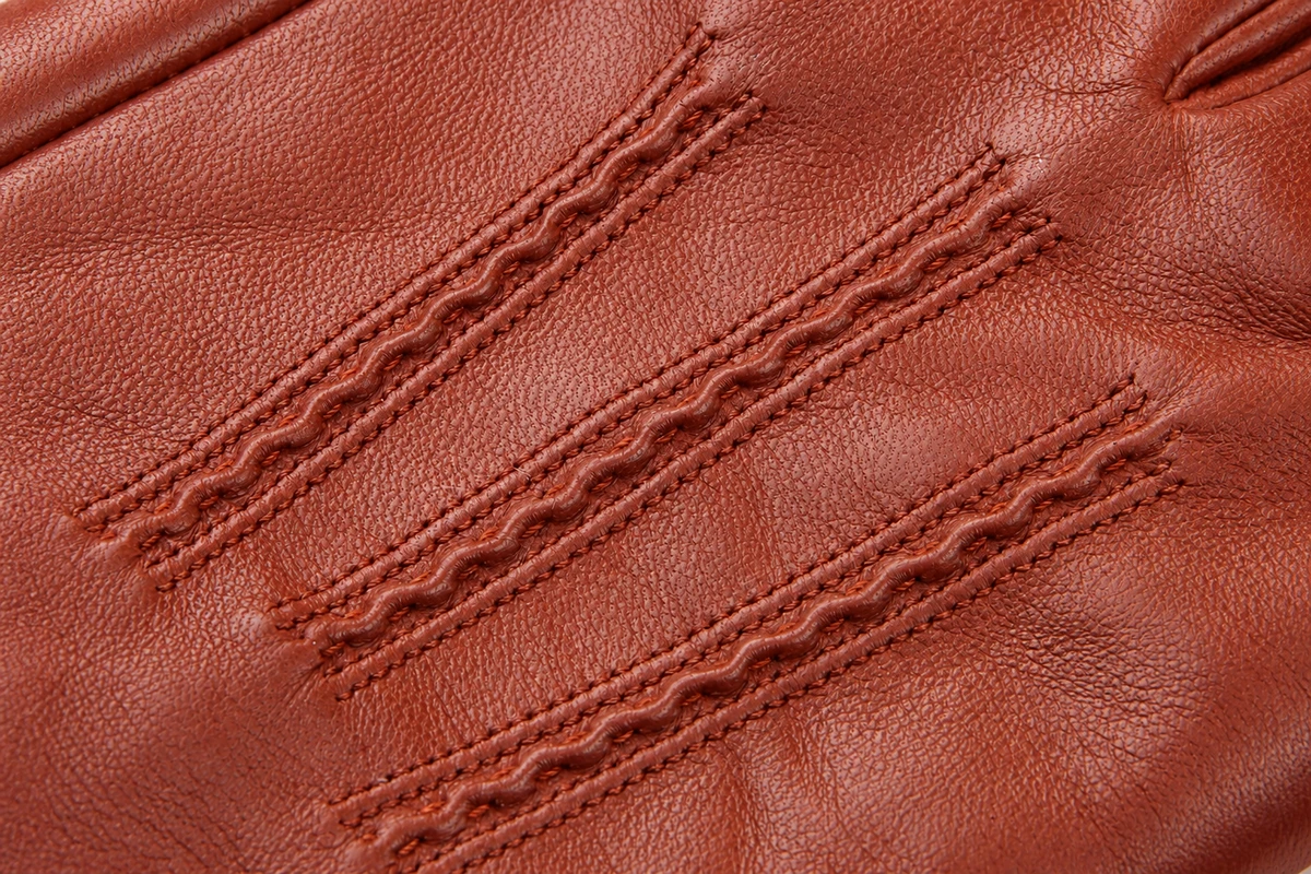 Raised decorative stitching on brown leather