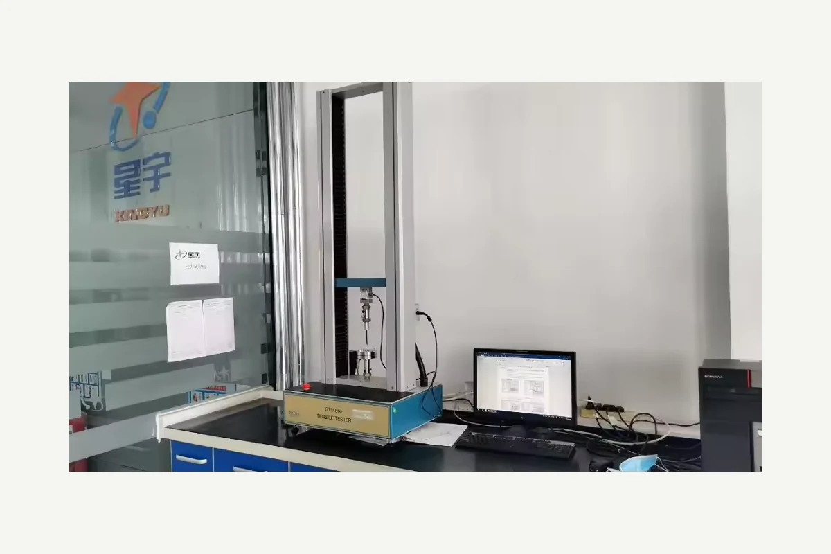 Laboratory test machine beside a monitor on a workbench