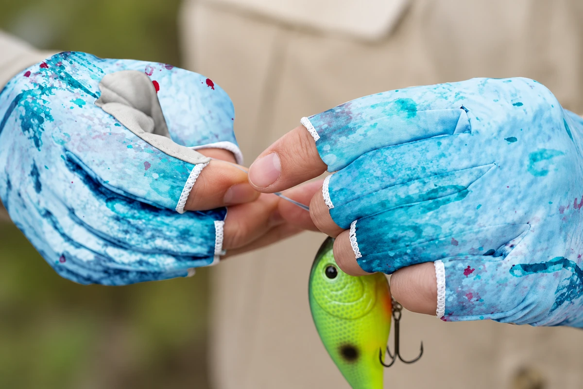Exposed fingertips and covered finger sections while handling fishing tackle