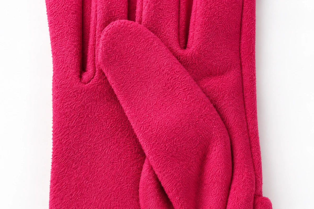 Panel seams around the thumb of a pink fleece glove