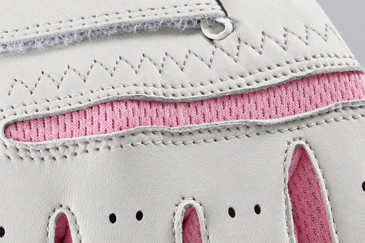Zigzag stitching and pink insert at a white glove wrist