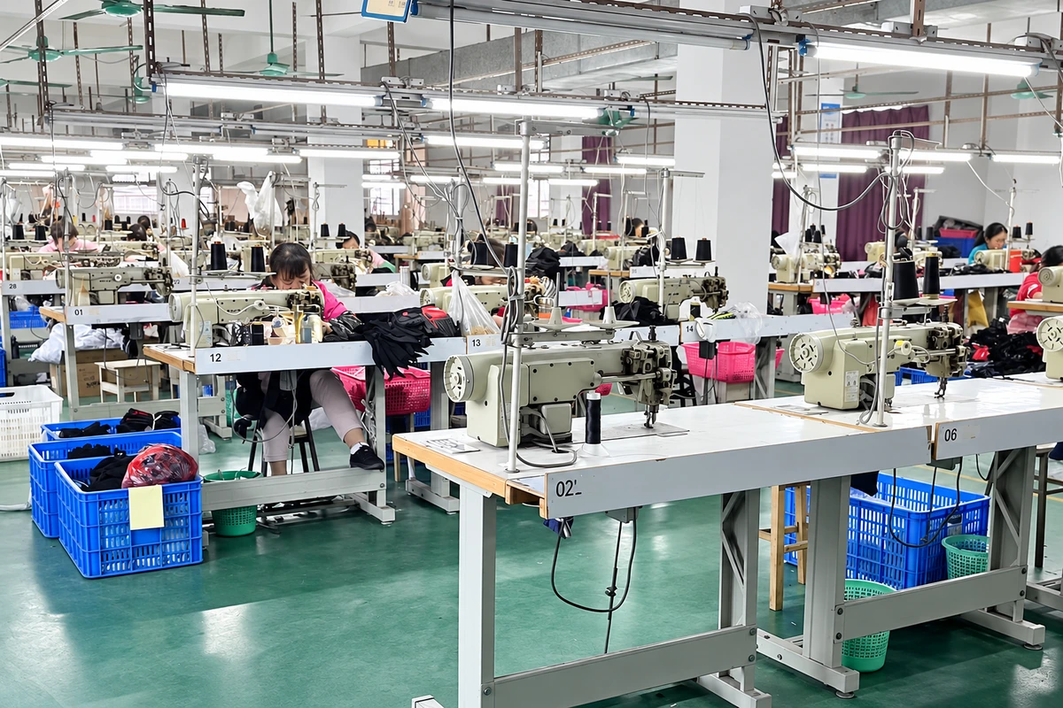 Rows of sewing machines and workers in a glove workshop