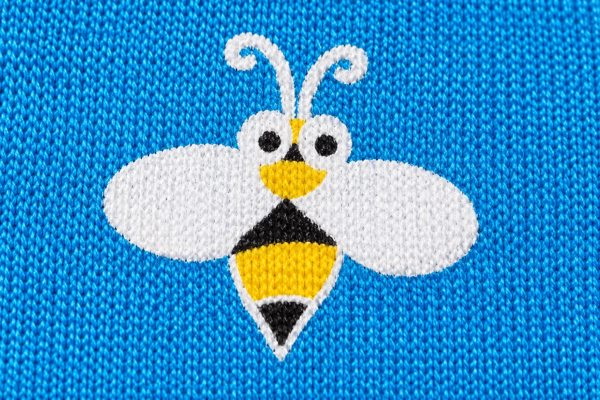 Bee artwork on blue knit fabric of a children’s garden glove