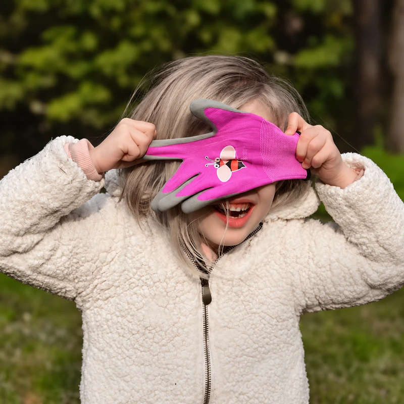 Child holding and stretching a pink garden glove
