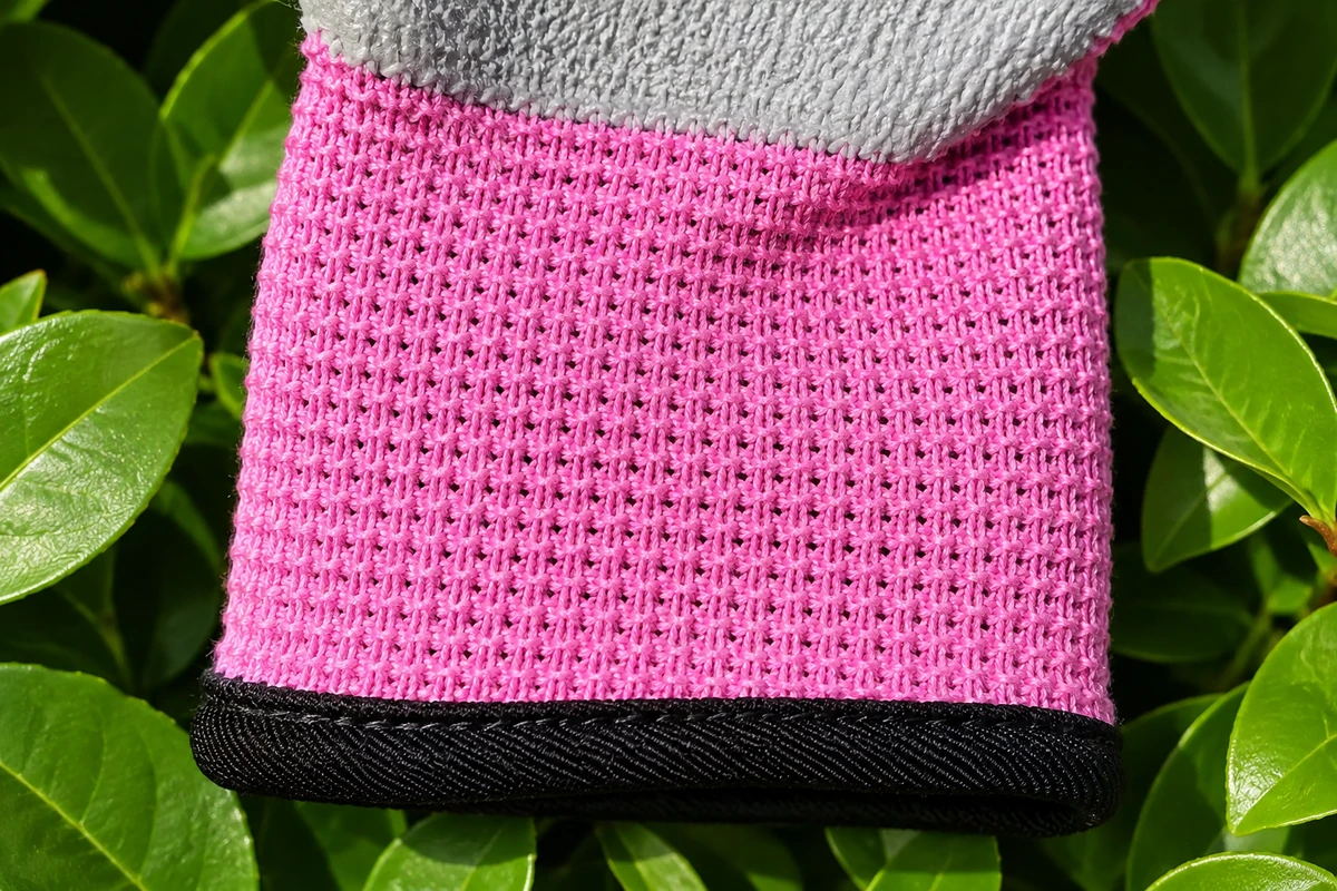 Pink ribbed cuff with black edge below a gray coated palm