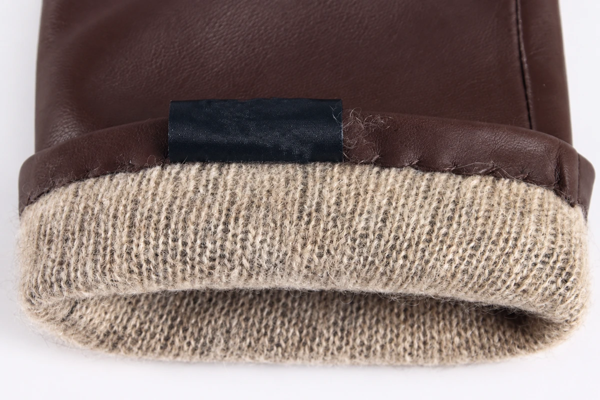 Brown leather cuff folded back to show beige knitted lining