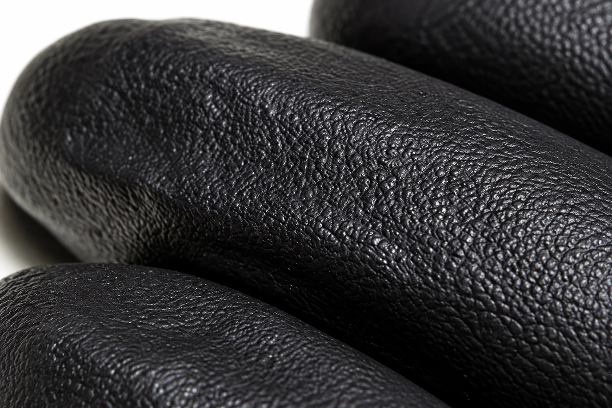 Close view of black disposable glove fingertip texture