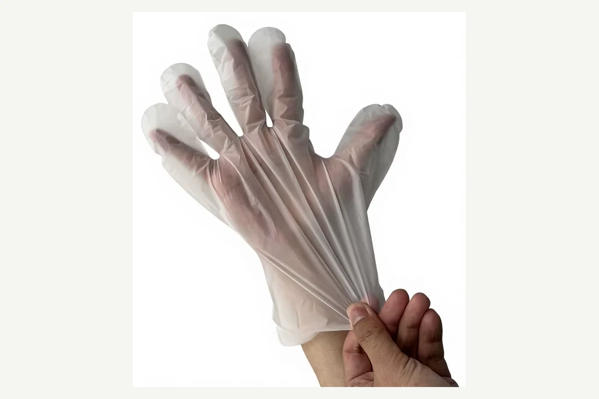 Clear film glove stretched at the cuff while worn on a hand