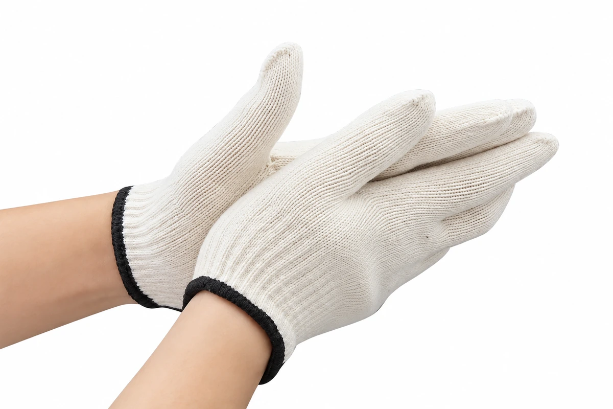 White knitted gloves worn on hands with dark cuff edging