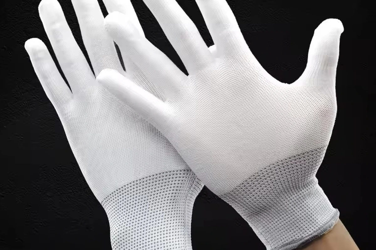 Close view of white knit glove fabric, seams and fitted cuffs