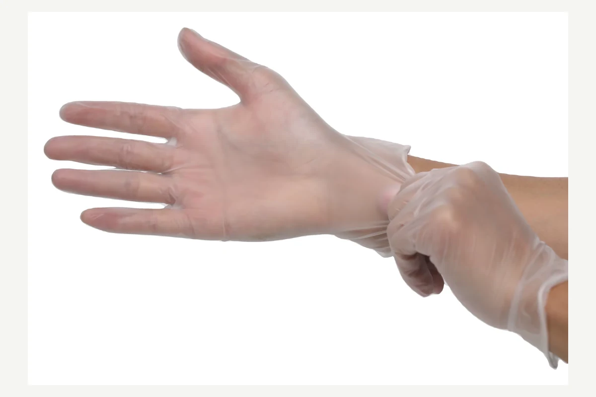 Clear disposable glove cuff being adjusted around the wrist