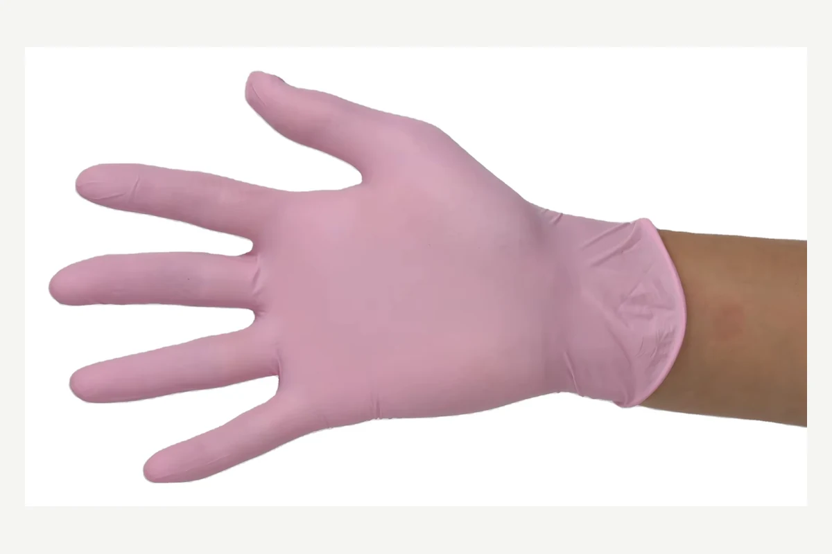 Pink disposable glove with spread fingers and a rolled cuff