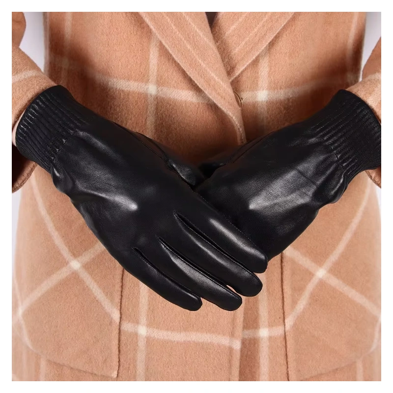 Black leather gloves with gathered wrists worn over a tan coat