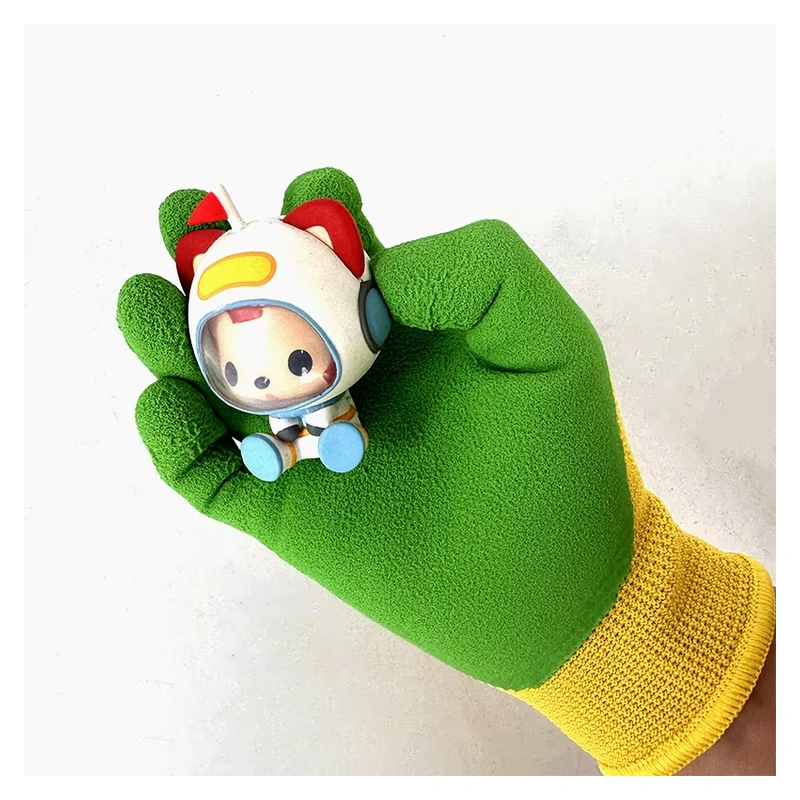 Green-coated glove with a yellow knit cuff holding a small toy figure