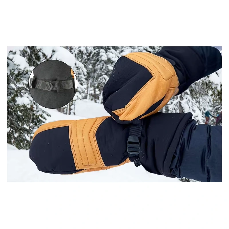 Navy and tan winter mittens with adjustable wrist straps shown in snow